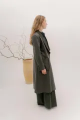 Tapado largo de corte recto y estilo minimalista, confeccionado en tela de color negro. Presenta solapas amplias, bolsillos frontales de parche y un diseño abierto que permite superponer capas.