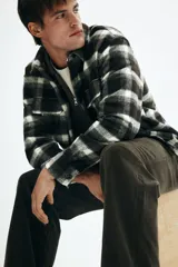 Pantalón de pana color marrón oscuro, con cintura clásica, cierre de botón, bolsillos laterales y bolsillos traseros insertados. Presenta un corte relajado.