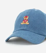 Gorra de jean celeste con visera curva y bordado de un oso en el frente.