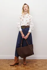 Camisa blanca de manga corta con cuello mao y volados, botones frontales y bordados de hojas y flores en color dorado.