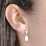 Aros colgantes de plata con forma de fresa texturizada en la parte superior y una perla ovalada colgando.