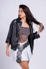 Minifalda negra de corte tableado con cinturón de cuero negro con hebilla plateada y tachas.