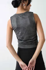 Top sin mangas de tela engomada con textura craquelada, color gris, con cuello redondo y detalle de frunces en los laterales.
