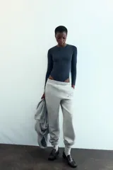 Body de manga larga con cuello redondo, confeccionado en una mezcla de algodón y modal. Presenta cierre inferior con botones a presión.