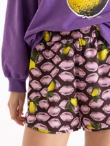 Short holgado de tiro medio, confeccionado en seda, con estampado de labios rosados y peras, cintura elastizada y ruedo redondeado con vivos contrastantes.