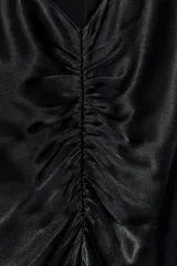 Vestido largo de satén negro con cuello halter subido y espalda descubierta. Presenta un diseño fluido con bajo en línea evasé.