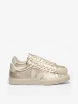 Championes Veja modelo Campo, con acabado metalizado en color dorado. Presentan un diseño minimalista con cordones al tono, suela de goma en color crema y el logo característico de la marca en el lateral.