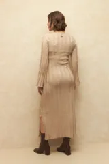 Vestido midi de punto acanalado en color gris, con mangas largas acampanadas y aberturas laterales en el ruedo. Presenta un diseño ajustado al cuerpo.