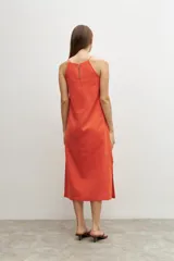Vestido midi color naranja de lino, con breteles finos y tajos laterales.