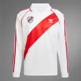 Camiseta de fútbol Adidas de manga larga de River Plate, modelo retro inspirado en 1994. Diseño en color blanco con la tradicional banda roja diagonal, cuello polo, y detalles en rojo en los hombros y las icónicas tres tiras en las mangas.