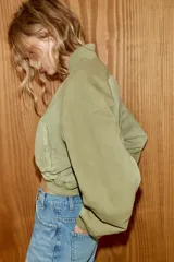 Chaqueta bomber de cuello redondo y manga larga con efecto lavado. Presenta bolsillos de vivo en el delantero, cierre frontal con cremallera y acabados en rib en cuello, puños y bajo.
