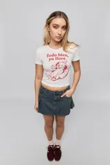 Remera blanca de manga corta y corte ajustado, con cuello redondo y estampa frontal en color rojo que incluye una ilustración y la frase "Todo bien, ya lloré.".