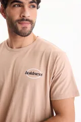 Remera color tostado de manga corta y corte regular fit, con estampa en la espalda dentro de un óvalo con la inscripción "boldness".