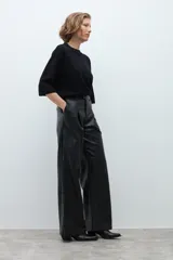 Pantalón de tiro alto confeccionado en eco cuero negro, con diseño de pierna ancha y pinzas frontales.