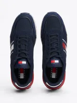 Zapatillas Tommy Jeans de corte bajo, color azul marino con detalles en rojo y blanco. Capellada de ante y malla, con logo de la marca en el lateral y suela de goma dentada.