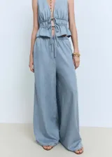 Pantalon palazzo de tiro medio confeccionado en tejido mezcla de algodón y lyocell. Presenta cintura con elástico, diseño largo y dos bolsillos laterales.
