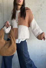 Sweater de punto con diseño de bloques de color en tonos camel y crudo, de corte holgado, cuello redondo y mangas largas con puños anchos.