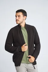 Campera tejida de algodón con cierre frontal completo, cuello alto y mangas largas con puños acanalados. Presenta un diseño de punto acanalado vertical y un pequeño logo bordado en el ruedo.