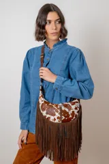 Bandolera de cuero con pelo estampado tipo animal print de ciervo, con flecos largos de gamuza en la parte inferior y correa ajustable.