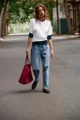 Camiseta de algodón color blanco con cuello redondo, mangas cortas y bajo abullonado, con detalles en color azul marino en el cuello, los puños y el ruedo.