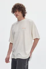 Remera boxy de manga corta y cuello redondo, con efecto de lavado acid wash en tono gris y estampa frontal en tonos rosado y rojo.