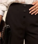 Short de sastrería negro, tiro alto, con cierre frontal de botones visibles.