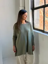 Sweater de tejido de punto color verde oliva, con cuello redondo, mangas largas y corte holgado con costura central vertical.