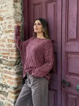 Sweater de punto con diseño de trenzas verticales, cuello redondo y mangas largas con caída holgada.