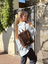 Camisa de corte oversize, con estampado a cuadros en tonos celeste, blanco y beige, cuello camisero, cierre frontal con botones y bolsillo aplicado en el pecho.