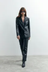 Pantalón de cuero sintético negro, de corte recto y tiro medio.