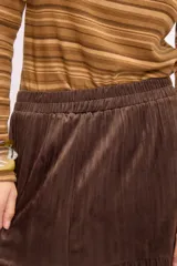 Falda larga de corte acampanado con diseño de paneles horizontales y textura símil terciopelo.