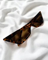 Lentes de sol de diseño cat-eye con armazón carey y cristales oscuros.