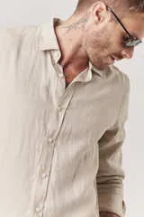 Camisa de lino color beige, de corte recto y manga larga.