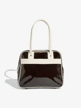 Bolso tipo shopper de Adidas, confeccionado en material sintético con acabado de charol brillante en color marrón oscuro y detalles en blanco. Presenta el logo del Trifolio estampado en el frente, bolsillo exterior con cierre y asas largas para llevar al hombro.