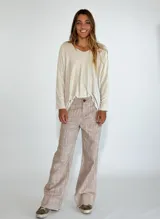 Pantalon de corte recto y tiro medio, confeccionado en tejido con textura jaspeada en tonos grises y azules, con ruedo desflecado.