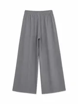 Pantalón gris de corte holgado y perneras anchas, con cintura elástica fruncida y cordón ajustable delantero.