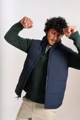 Chaleco puffer de color azul marino, con cierre frontal completo y cuello alto. Presenta un diseño acolchado horizontal y el logo de la marca bordado en el pecho.
