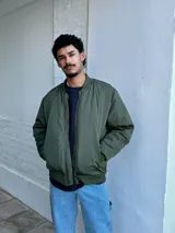 Campera bomber verde militar de nylon con cierre frontal y bolsillos laterales.