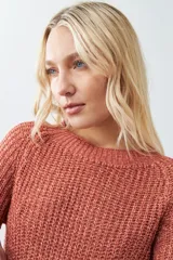 Sweater tejido de punto color rojo con cuello redondo y ruedo curvo.