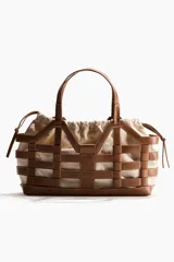 Bolso tipo tote grande de tela revestida marrón con estructura exterior trenzada imitando cuero y bolsa interior de lona de algodón y lino con cordón ajustable.