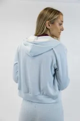 Campera beige con capucha, cierre frontal de metal y bolsillos tipo canguro.