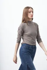 Polera de algodón color blanco, con cuello alto y mangas tres cuartos. Presenta un diseño ajustado al cuerpo con costuras decorativas en las sisas.