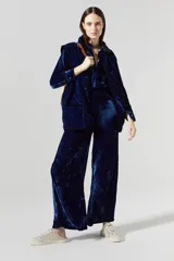 Pantalón de terciopelo azul marino, de tiro alto, con cintura elástica en la espalda, cierre frontal, bolsillos laterales y piernas anchas.