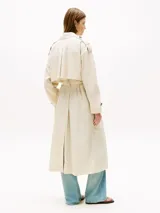 Gabardina larga color beige claro, con corte oversize, solapas con muescas, cierre de botones y cinturón anudable.