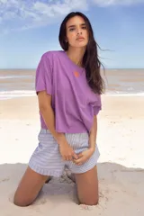 Remera lila de algodón con corte cuadrado y logo bordado en color naranja.