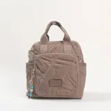 Mochila de diseño acolchado con pespuntes geométricos, color caqui. Cuenta con doble asa superior, bolsillo frontal con cierre y compartimentos laterales. Incluye un colgante decorativo con cuentas de colores en el cierre frontal.