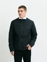 Campera de estilo casual con cierre frontal, cuello alto con broche y bolsillos laterales con cierre. Presenta un diseño liso y funcional, ideal para uso diario.
