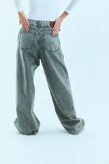 Jean de corte oversize con tiro medio-alto, confeccionado en denim de algodón con lavado tipo ice wash en tono grisáceo. Presenta diseño de cinco bolsillos, cierre frontal y etiqueta de cuero en la parte posterior de la cintura.