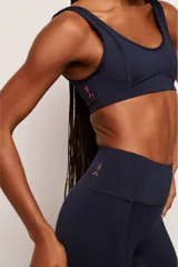 Calza deportiva de tiro alto con diseño de costuras curvas laterales y efecto modelador. Confeccionada en tejido técnico de alta compresión, ideal para entrenamientos de alta intensidad.
