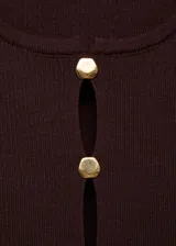Chaleco de punto fino color marrón oscuro, sin mangas, con cuello redondo y cierre frontal con botones tipo joya dorados que dejan pequeñas aberturas.